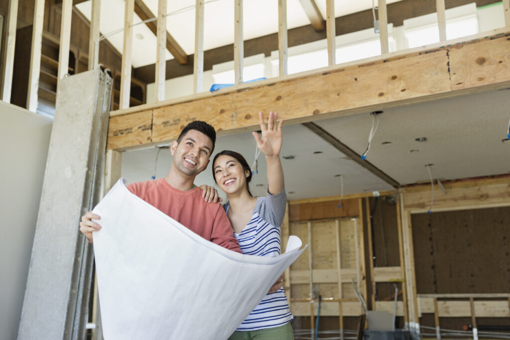 Couple looking at blueprints to expand their home.